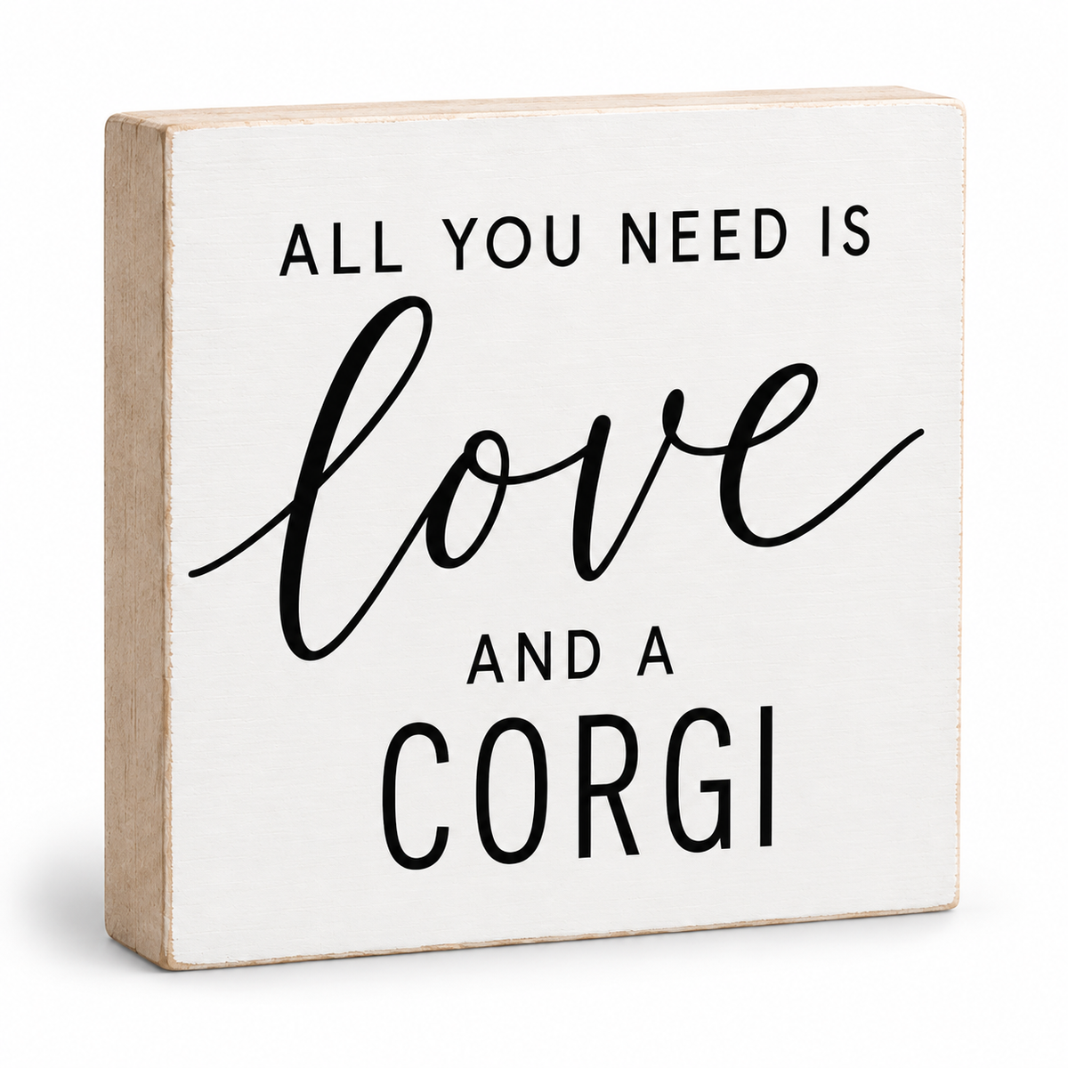 A square decorative wooden sign with a white face and natural light wood edges, printed with the phrase 'ALL YOU NEED IS love AND A CORGI' in black lettering, shown on a clean white background.