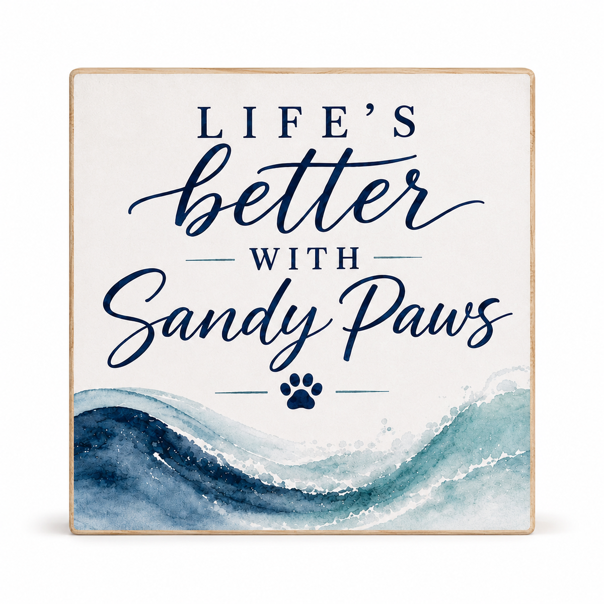 Square decorative wall sign with the phrase “LIFE’S better WITH Sandy Paws” in navy lettering on an off-white background, with a blue watercolor wave design at the bottom and a small paw print. The sign has a light natural wood border and is photographed against a clean white background.