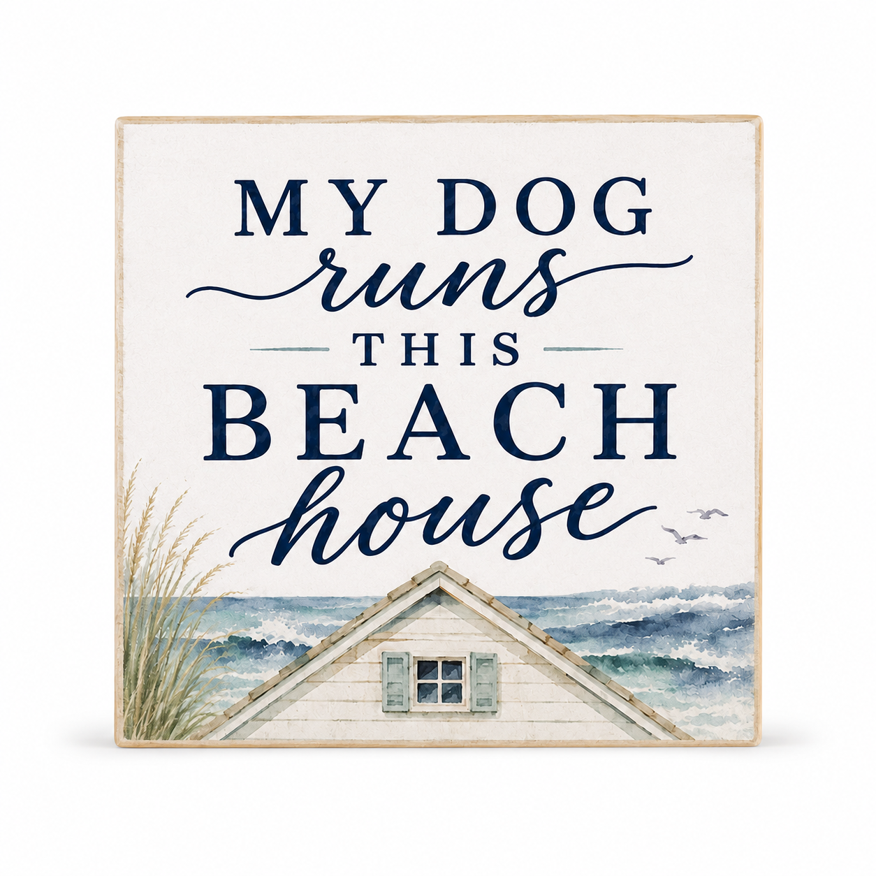 Square decorative wall sign with the phrase “MY DOG runs THIS BEACH house” in navy lettering on an off-white background, with a painted beach house, ocean waves, and grass along the bottom. No person, animal, or real environment is present, so this is Product/Packaging rather than Lifestyle or Scenery.