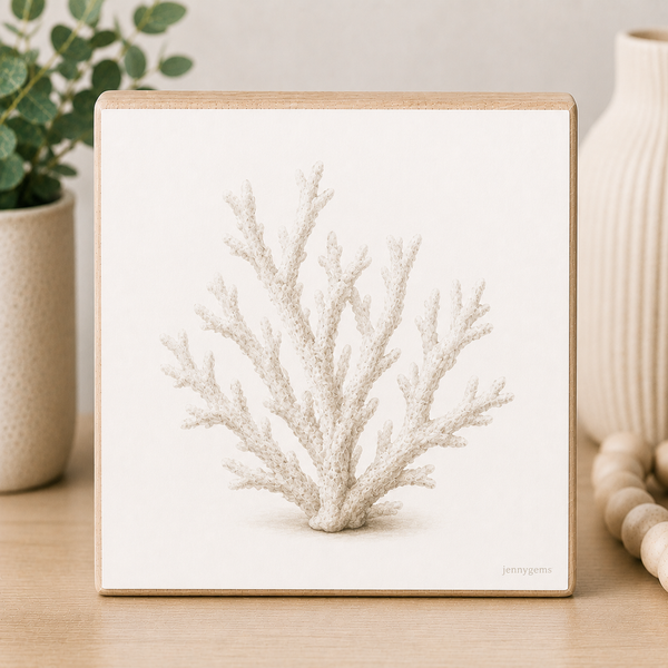 Framed print of a white coral on a wooden surface with decorative items.