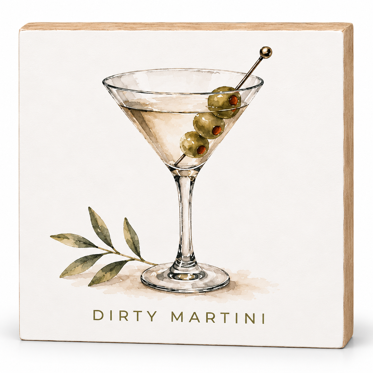 A square decorative sign with a light wood border and an off-white face, printed with a watercolor-style martini glass, three olives on a skewer, a leafy sprig, and the words “DIRTY MARTINI” in gold at the bottom.