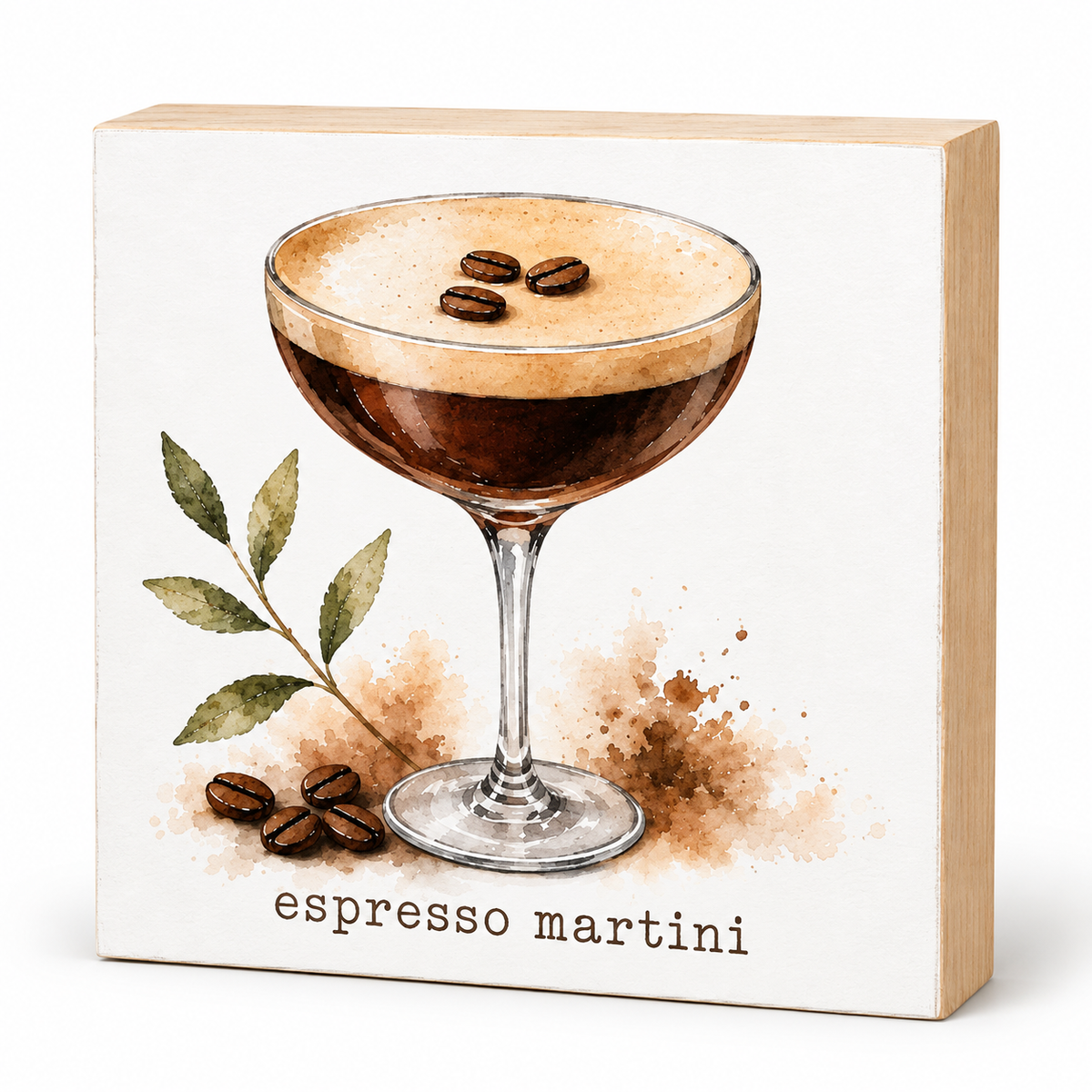 A square decorative block or plaque with a printed illustration of an espresso martini in a coupe glass, plus coffee beans, leaves, and the text 'espresso martini' on a white front panel with a light wood side edge, shown on a white background.