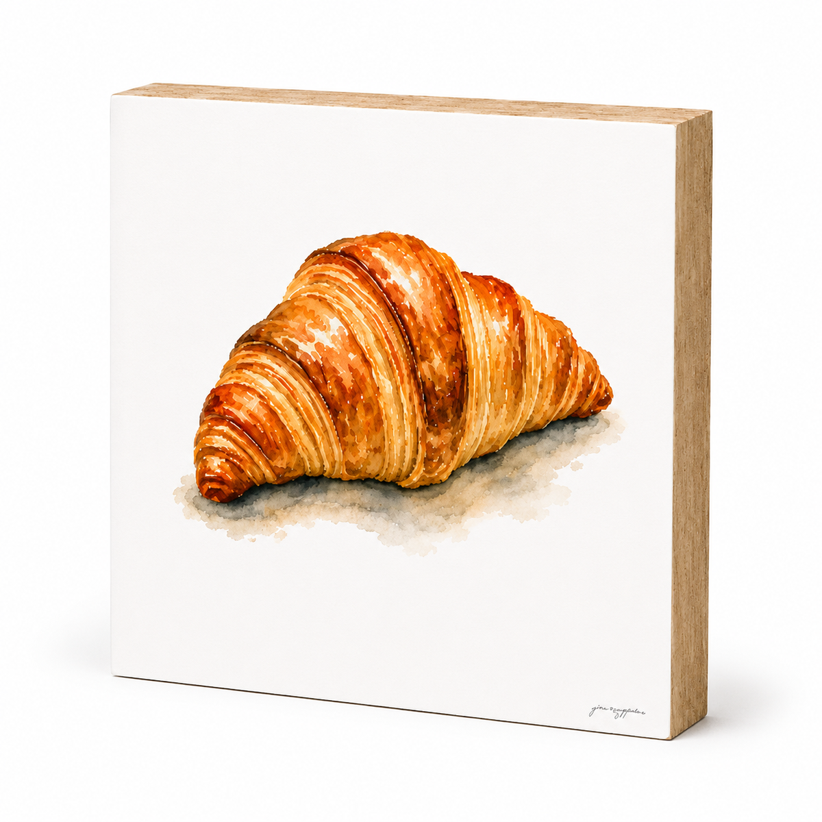 A square canvas print with a light wood frame, featuring a watercolor painting of a golden-brown croissant on a white background.