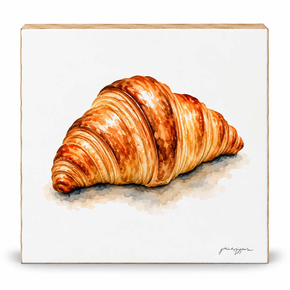 A square canvas print featuring a watercolor-style illustration of a golden-brown flaky croissant on a white background, shown as a physical canvas block with a light wood frame against a clean white backdrop.