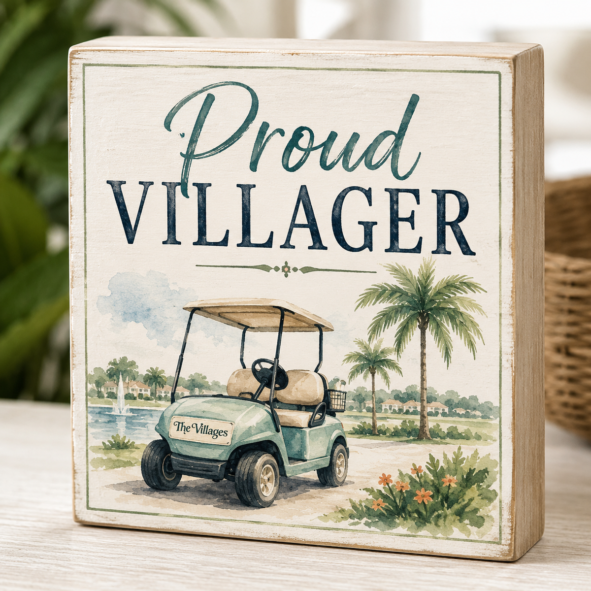 Decorative sign with 'Proud Villager' text and golf cart illustration on a wooden surface.