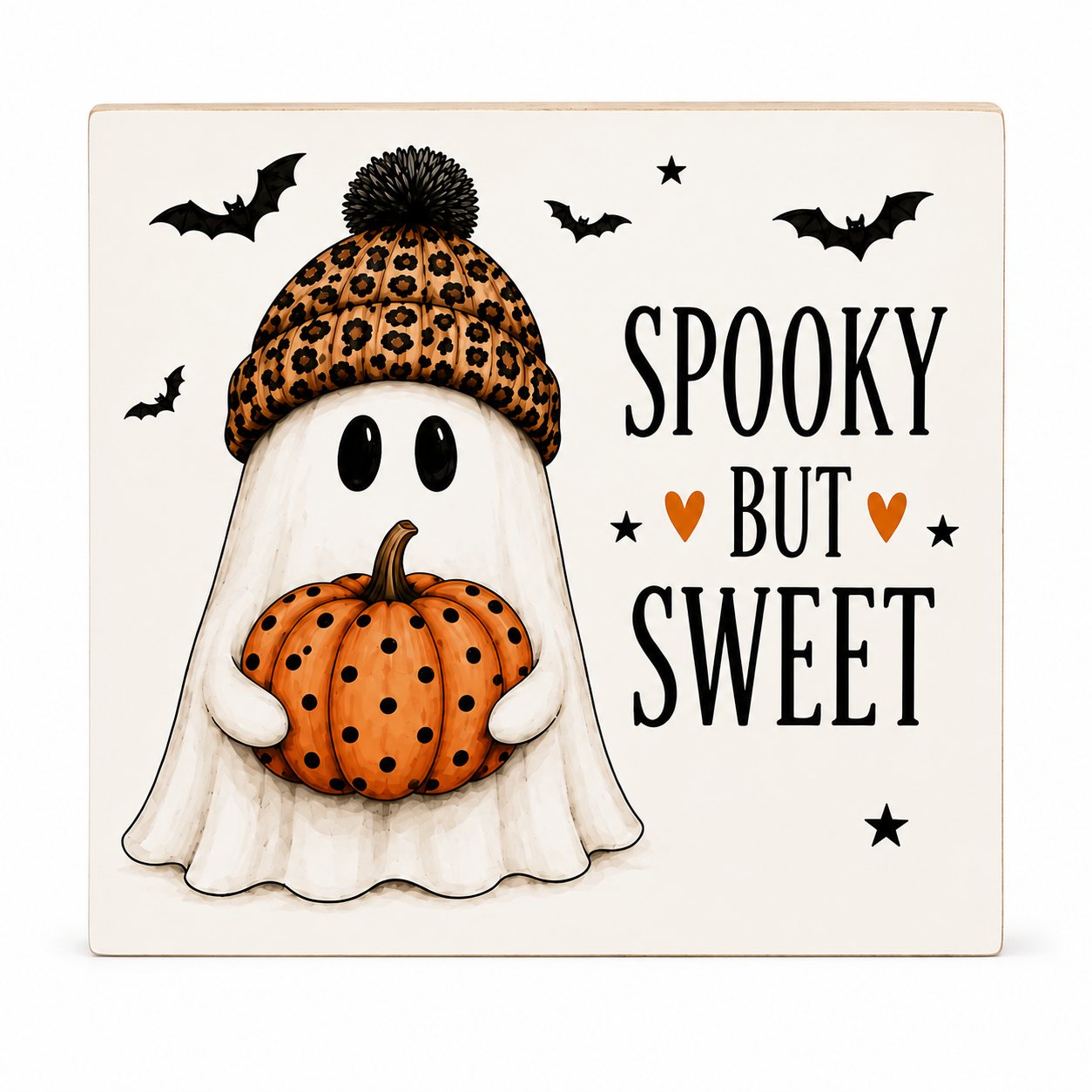 Square decorative sign with a Halloween illustration featuring a ghost in a leopard-print beanie holding an orange pumpkin, with the words “SPOOKY BUT SWEET,” bats, stars, and hearts on an off-white background.