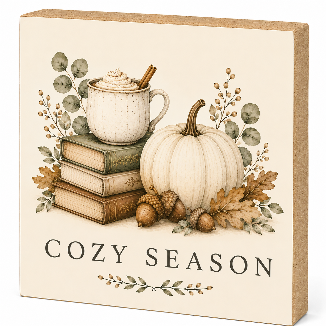 A square decorative sign with a warm autumn design, featuring a white mug on stacked books, a white pumpkin, acorns, and fall leaves, with the text 'COZY SEASON' at the bottom. The sign has a beige face and a natural wood-toned side edge, shown on a plain white background.