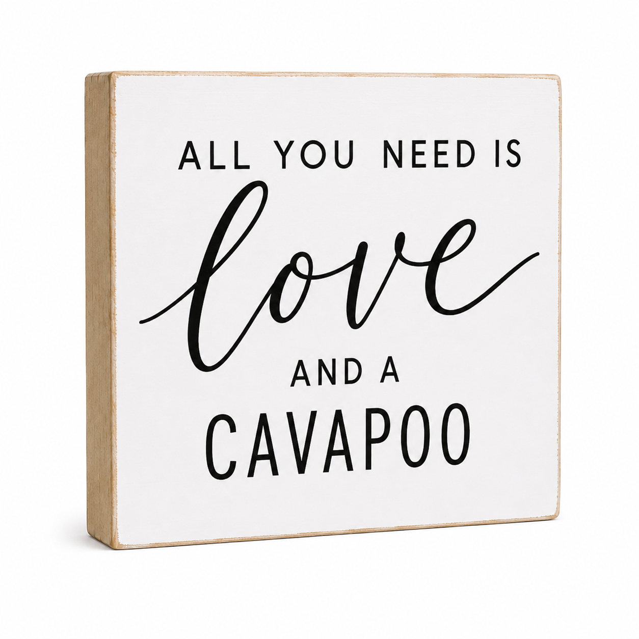 A square white decorative wooden sign with a natural wood edge and black text that reads 'ALL YOU NEED IS love AND A CAVAPOO' on a clean white background.