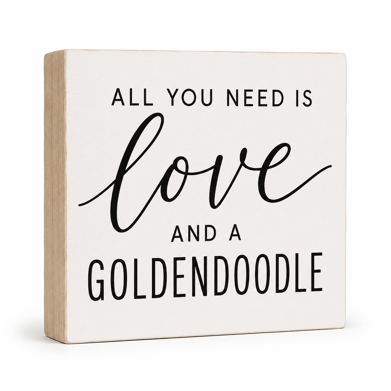 A square decorative wooden sign with a warm off-white face and natural light wood edges. The sign features black text that reads 'ALL YOU NEED IS love AND A GOLDENDOODLE' on a clean white background.