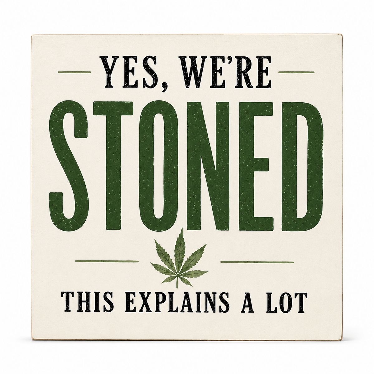 A square decorative sign with a cream background and printed text reading “YES, WE’RE STONED THIS EXPLAINS A LOT,” with large dark green “STONED” lettering and a green leaf graphic in the center.