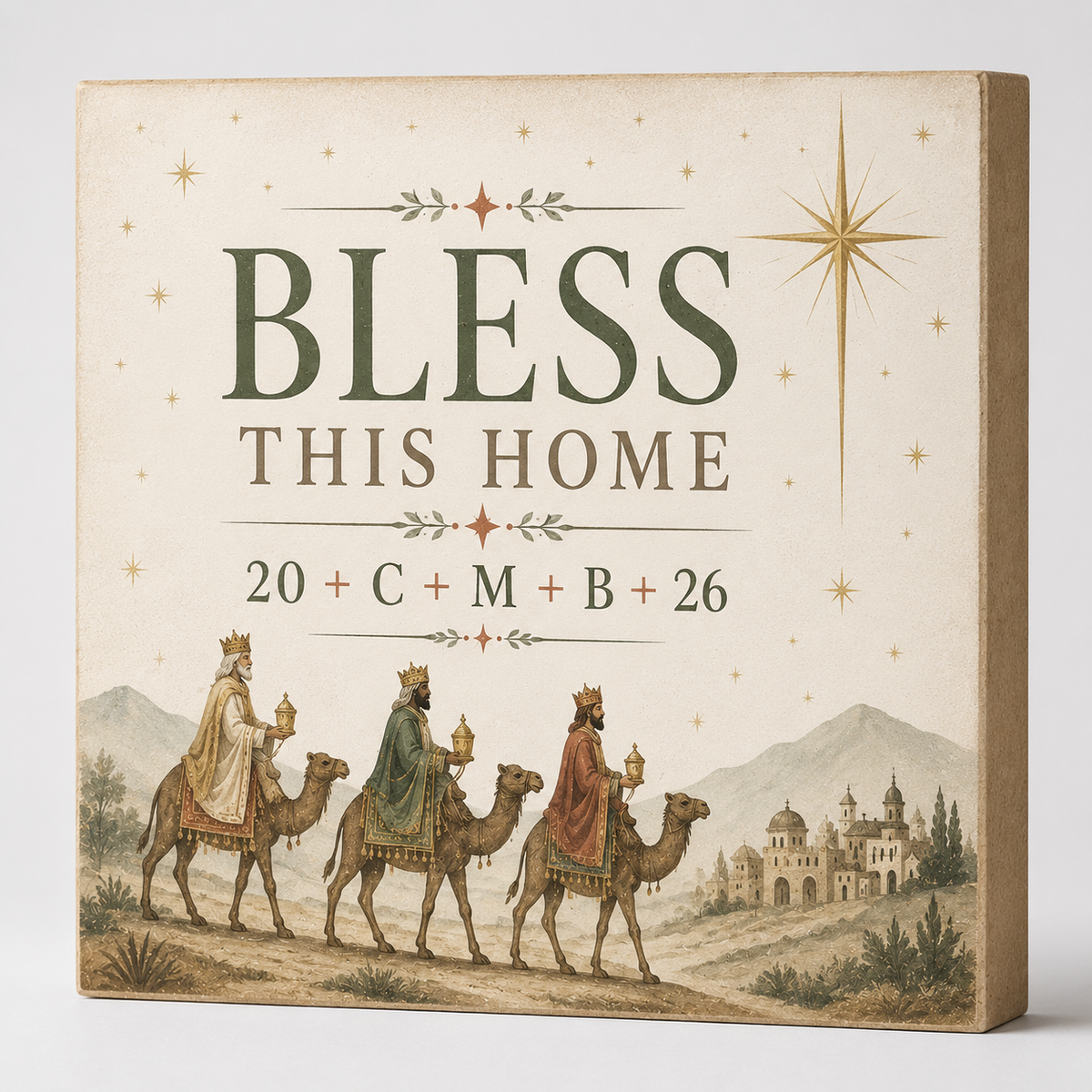 A square decorative sign or box front with the words “BLESS THIS HOME” and “20 + C + M + B + 26,” decorated with a vintage-style Christmas scene showing three wise men on camels, stars, mountains, and a castle. The product is photographed against a plain light background.
