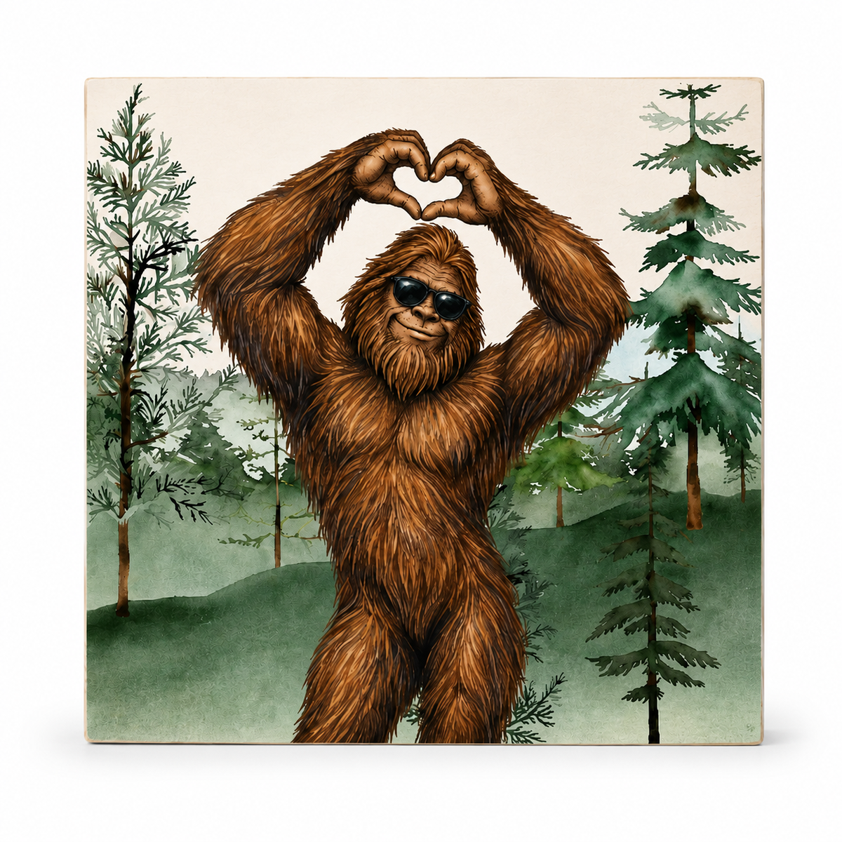 A square ceramic tile featuring a whimsical illustration of a brown furry Bigfoot-like figure wearing sunglasses and forming a heart with his hands, set against a watercolor-style forest background.