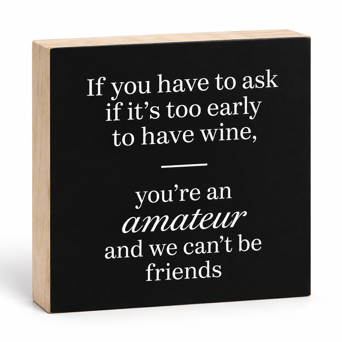 A square decorative block sign with a black front panel and natural wood sides, printed with the quote: 'If you have to ask if it's too early to have wine, you're an amateur and we can't be friends' in white text.