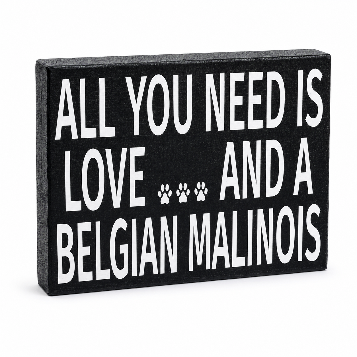 A rectangular black decorative sign with bold white text reading 'ALL YOU NEED IS LOVE.
