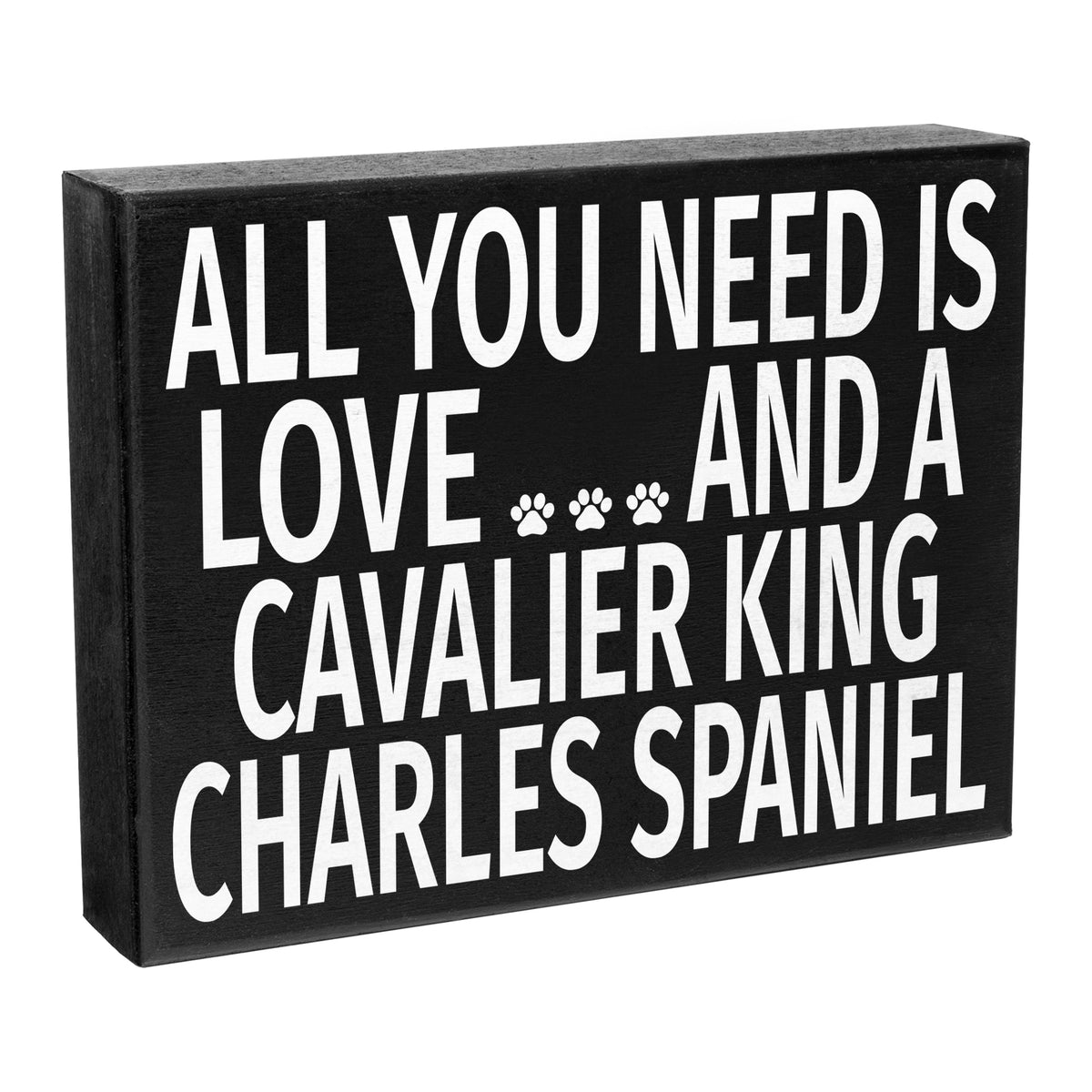 A black wooden sign with the text 'All You Need Is Love and a Cavalier King Charles Spaniel' and a paw print symbol.