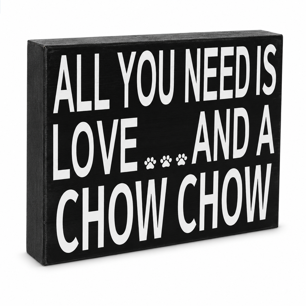 A rectangular black decorative sign with bold white text reading 'ALL YOU NEED IS LOVE.