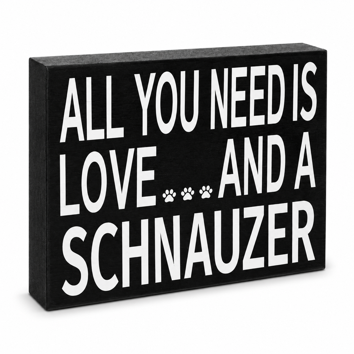A rectangular black decorative sign with bold white text reading 'ALL YOU NEED IS LOVE.