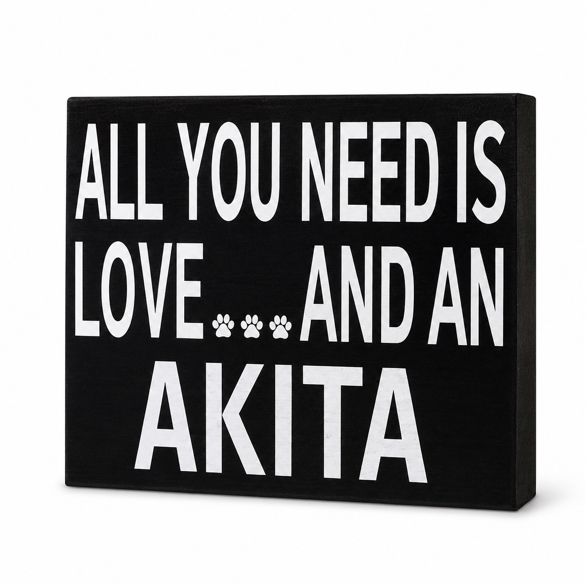 A rectangular black sign with bold white text reading 'ALL YOU NEED IS LOVE.