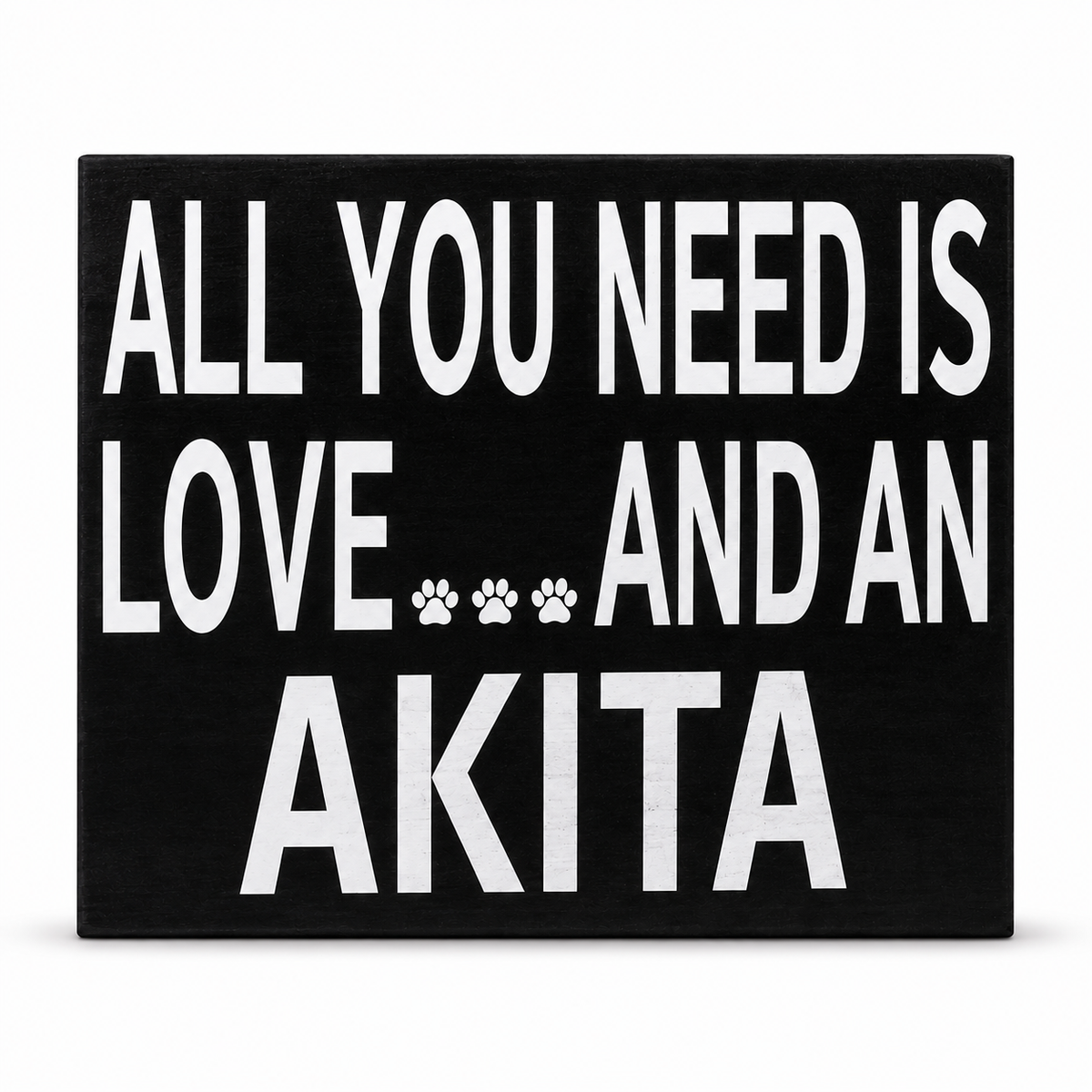 A rectangular black sign with bold white text reading 'ALL YOU NEED IS LOVE.