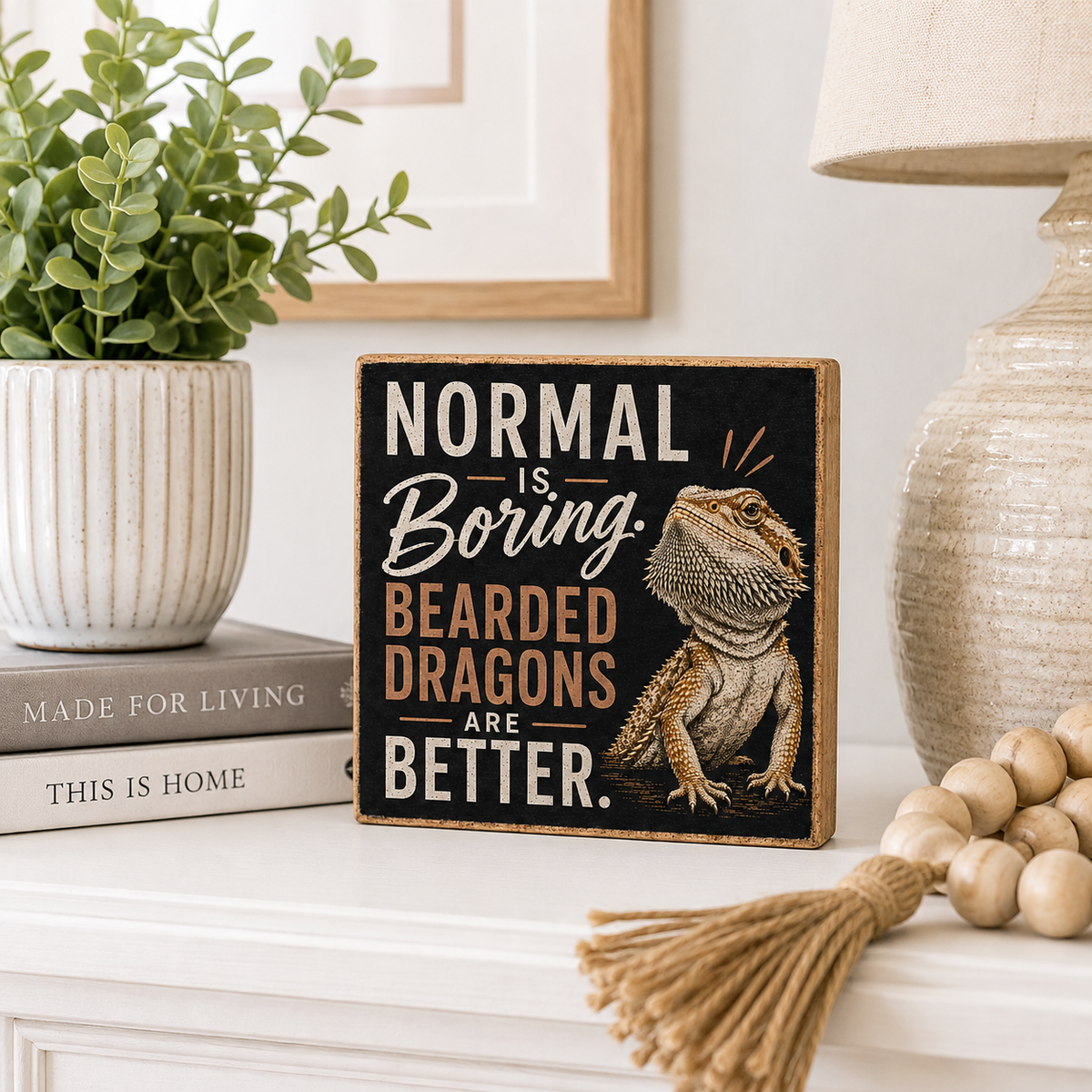 A square decorative sign with a black background and a bearded dragon illustration, reading “NORMAL IS Boring. BEARED DRAGONS ARE BETTER.