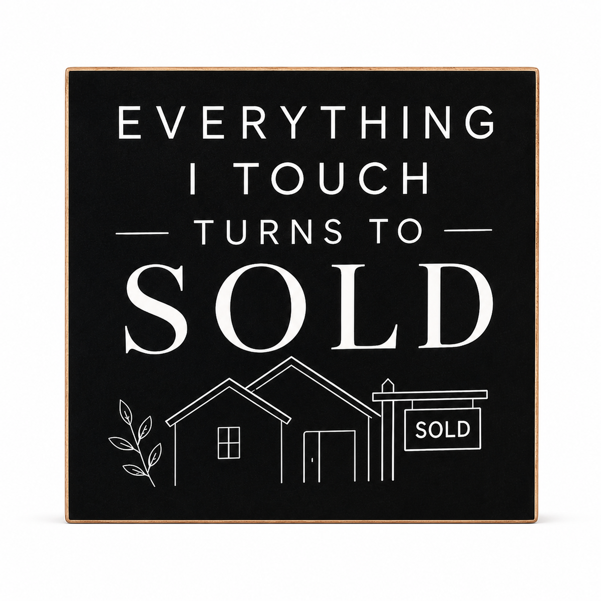 A square black decorative wall sign with a thin natural wood border, featuring white text that reads 'EVERYTHING I TOUCH TURNS TO SOLD' above simple white line drawings of a house and a sold sign, shown on a light gray background.