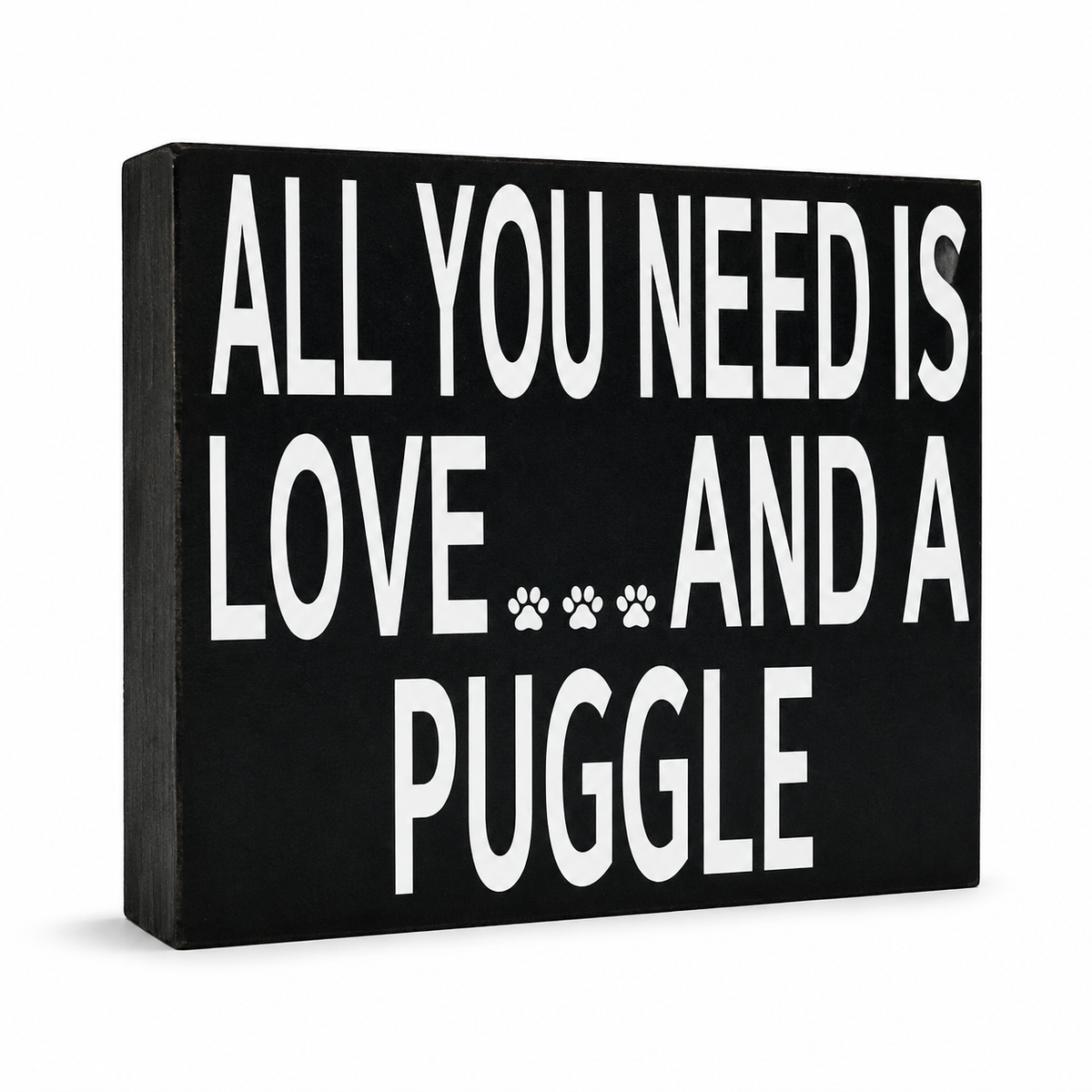 A rectangular black wooden sign with bold white text reading 'ALL YOU NEED IS LOVE.