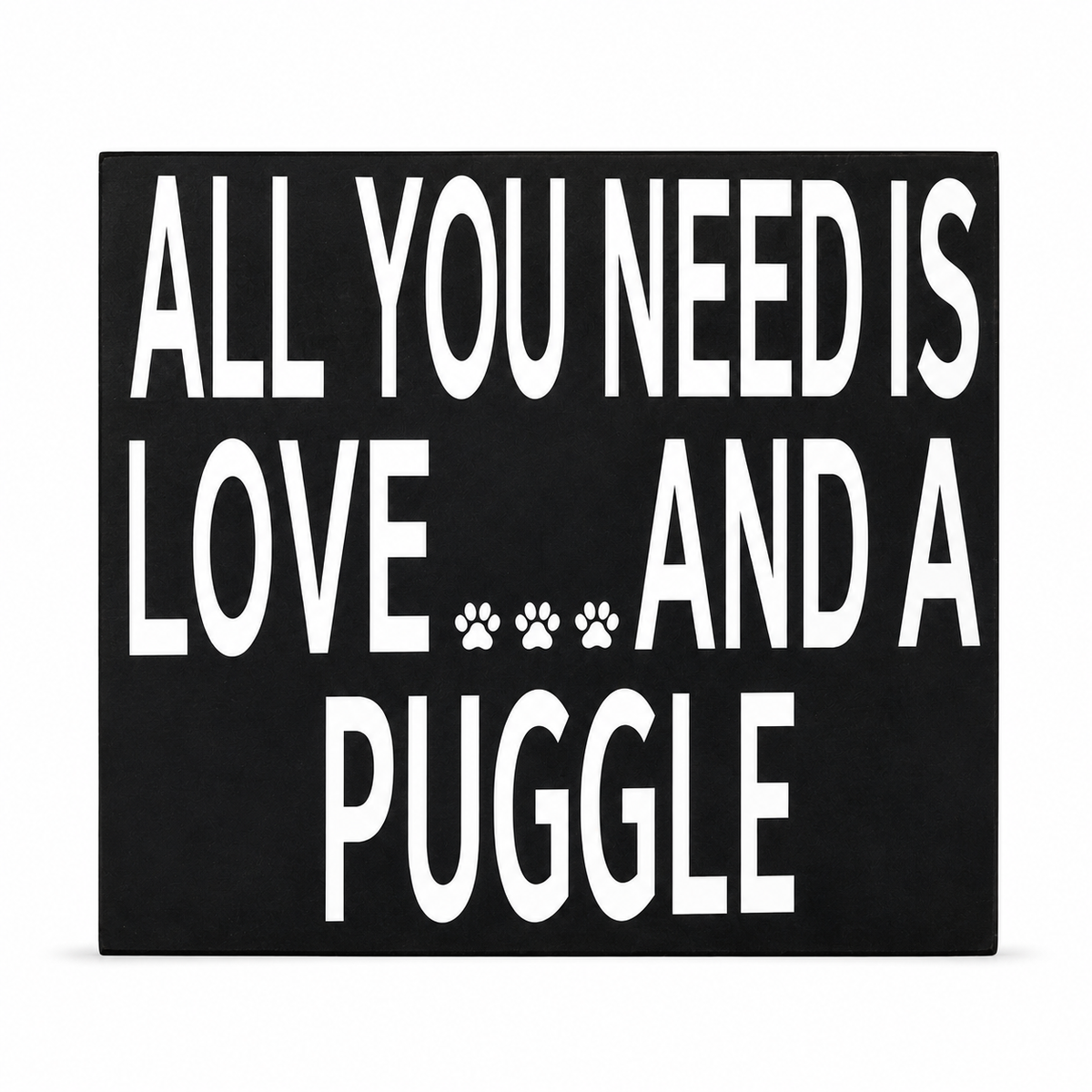 A square black sign with bold white text reading 'ALL YOU NEED IS LOVE.