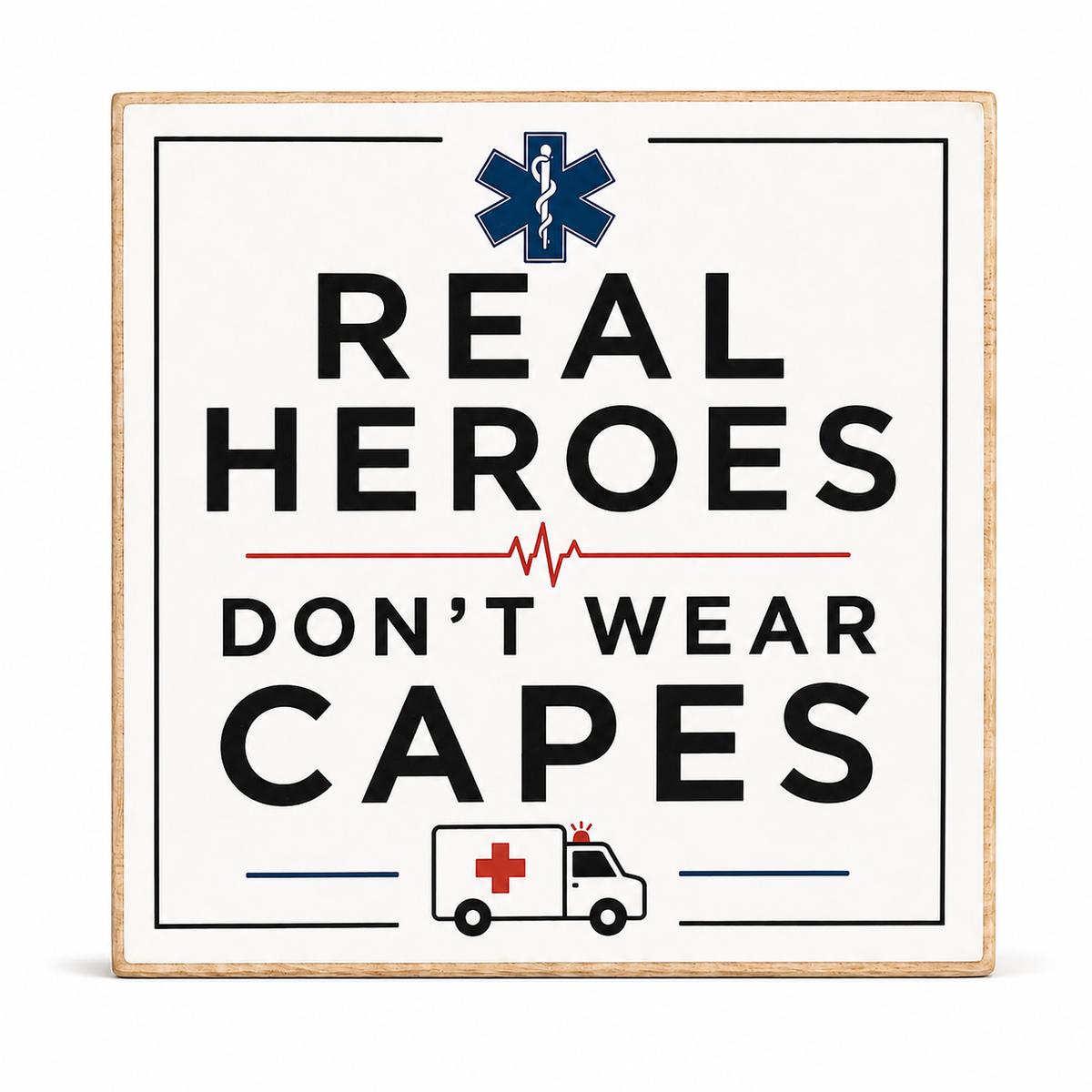 A square decorative sign with a light wood border and an off-white face, featuring the text 'REAL HEROES DON'T WEAR CAPES' in black, a navy blue Star of Life symbol at the top, a red heartbeat line in the middle, and a small ambulance illustration at the bottom.