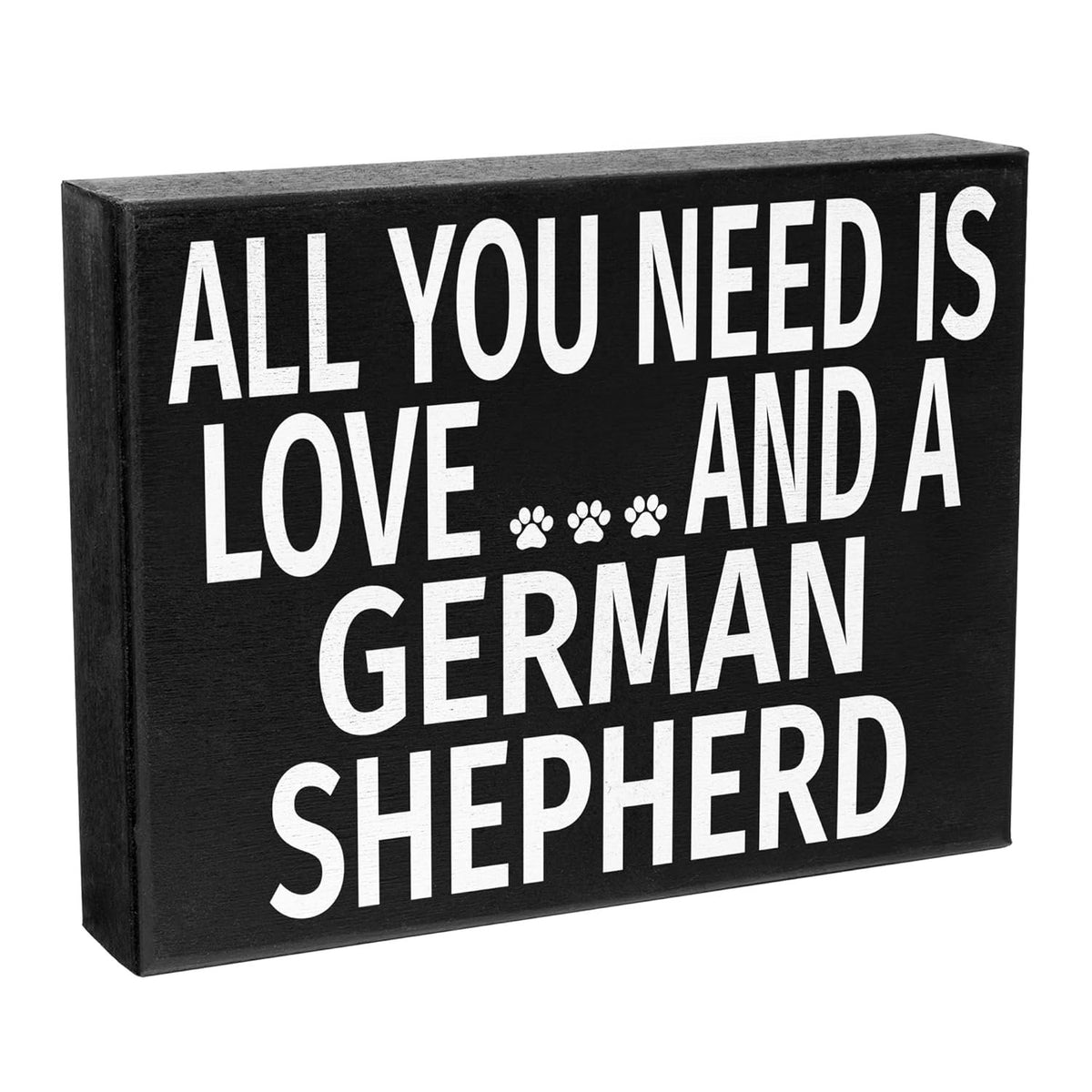 A rectangular black wooden sign with bold white text reading 'ALL YOU NEED IS LOVE.