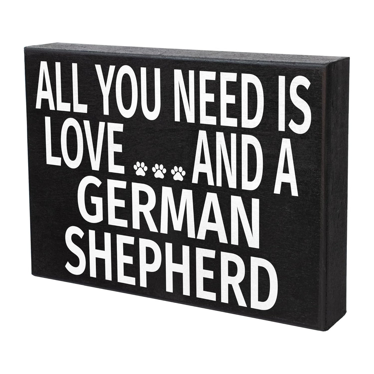 A rectangular black decorative sign with bold white text reading 'ALL YOU NEED IS LOVE.