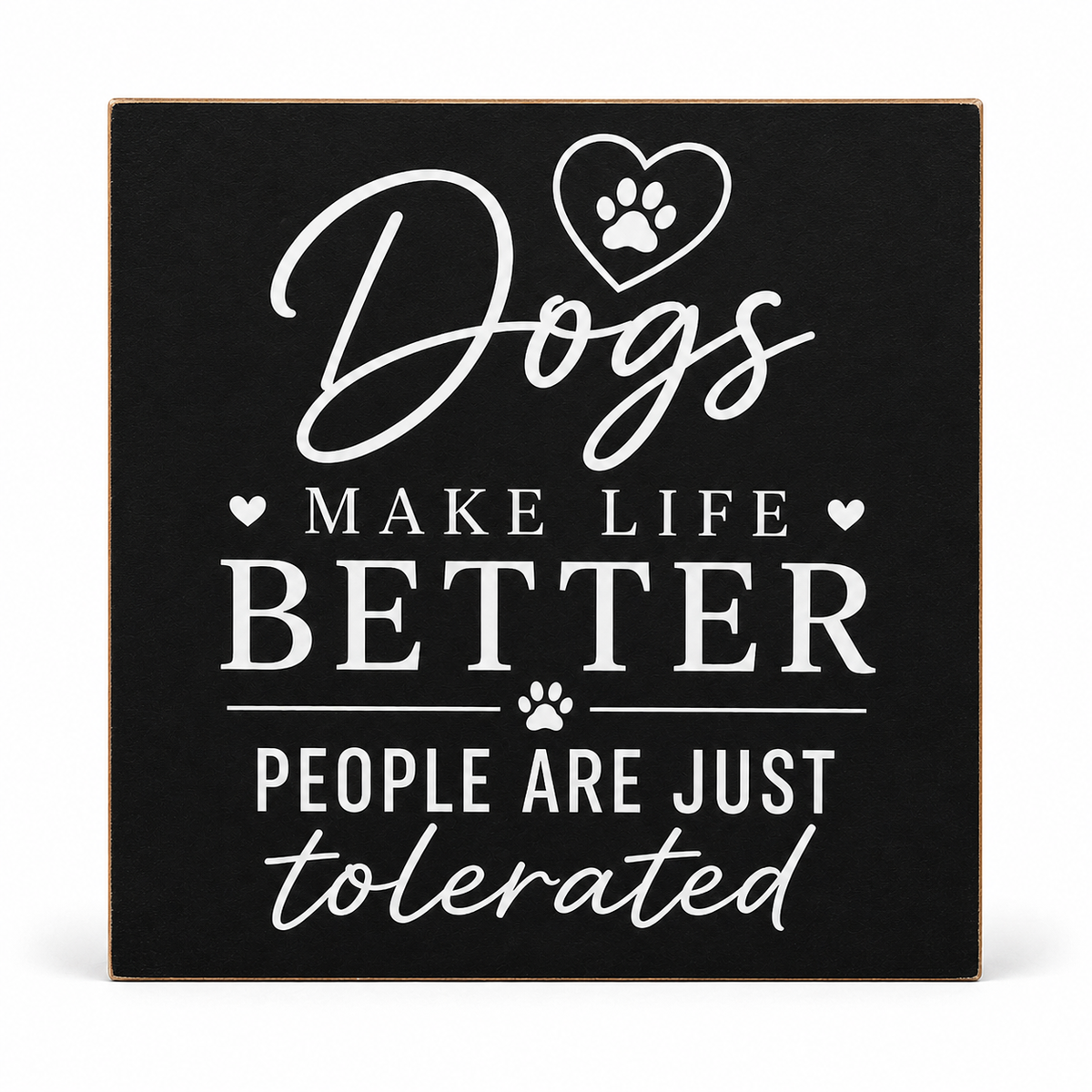 A square black decorative sign with a thin light wood border, featuring white text that reads “Dogs make life better people are just tolerated,” along with a heart outline containing a paw print and small paw prints.