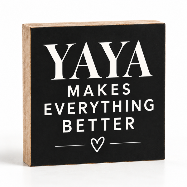 A square decorative wooden block sign with a black front and natural wood sides, printed with the phrase “YAYA MAKES EVERYTHING BETTER” in white text with a small heart below.
