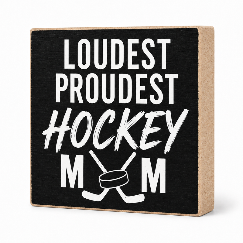 A square decorative wooden block sign with a black front and natural wood sides, printed with the phrase 'LOUDEST PROUDEST HOCKEY MOM' in white lettering with crossed hockey sticks and a hockey puck graphic.