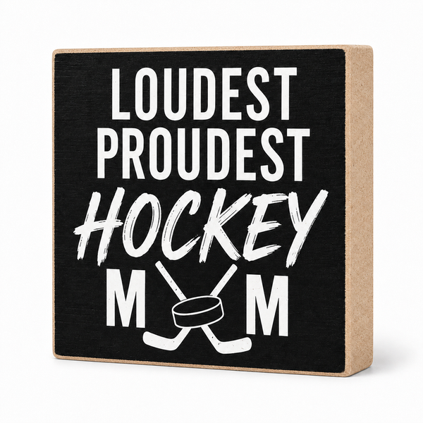 A square decorative wooden block sign with a black front and natural wood sides, printed with the phrase 'LOUDEST PROUDEST HOCKEY MOM' in white lettering with crossed hockey sticks and a hockey puck graphic.
