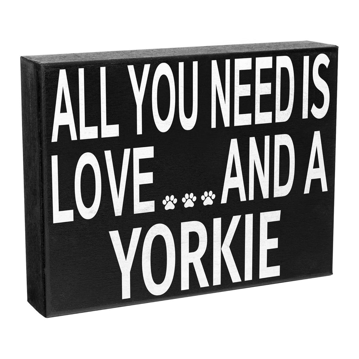 A rectangular black wooden sign with bold white text reading 'ALL YOU NEED IS LOVE.