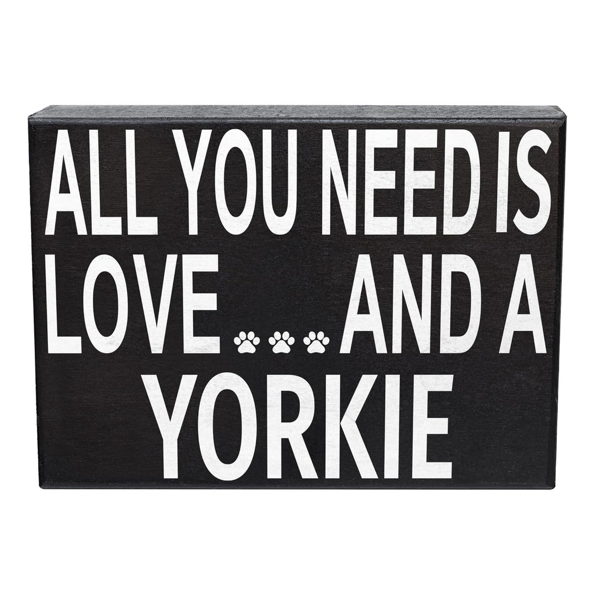 A rectangular black wooden sign with bold white text reading 'ALL YOU NEED IS LOVE.