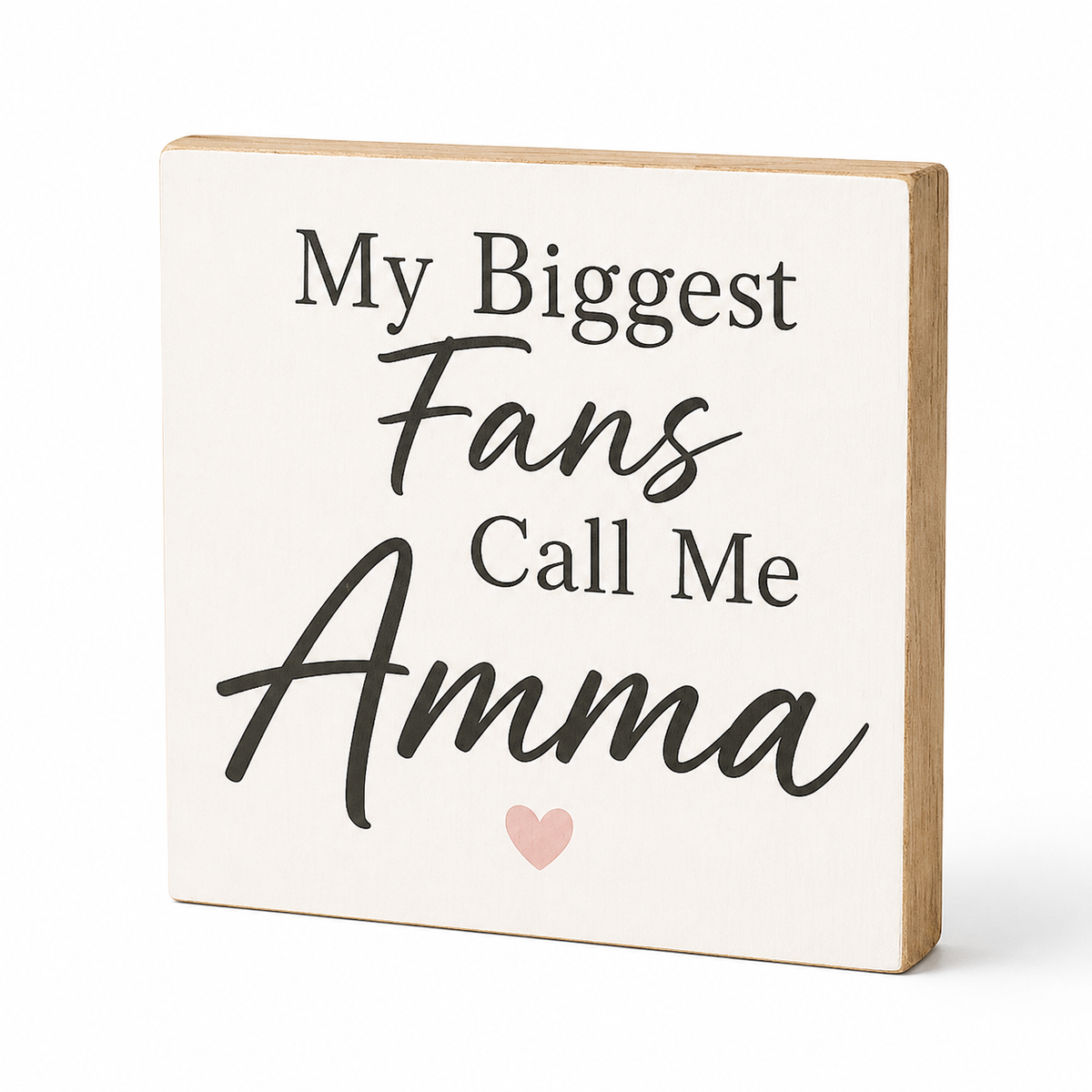 A square decorative wooden sign with a cream face and natural wood edges, printed with the phrase 'My Biggest Fans Call Me Amma' in black lettering and a small light pink heart at the bottom, shown on a white background.