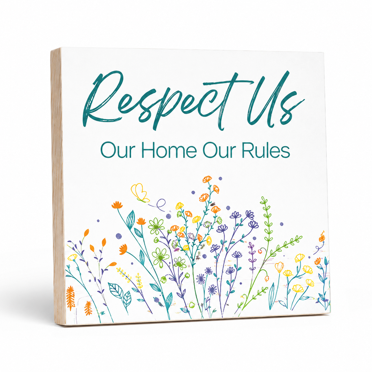 A square decorative sign with a white face and natural wood edges, featuring the text 'Respect Us Our Home Our Rules' in teal, with a colorful wildflower illustration along the bottom.