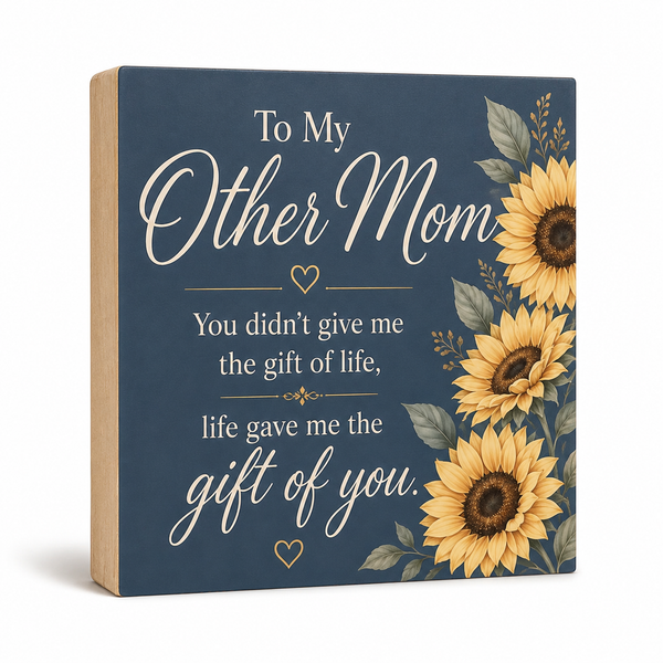 A square decorative sign with a navy blue front and natural wood sides, featuring the phrase 'To My Other Mom You didn't give me the gift of life, life gave me the gift of you.' in white script and serif text, alongside yellow sunflowers and green leaves on the right side.