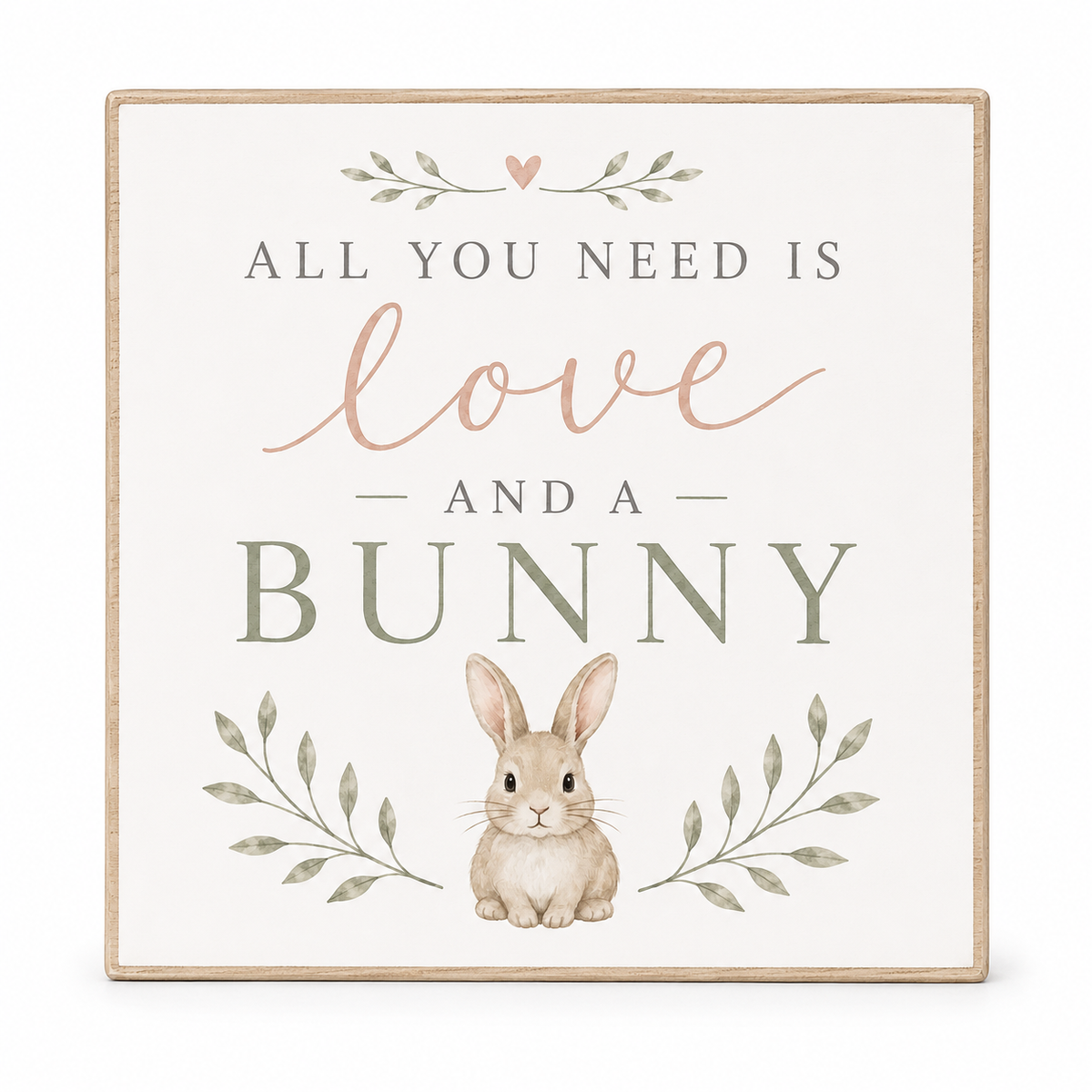 Square decorative wall sign with a light wood border, featuring the phrase 'ALL YOU NEED IS love AND A BUNNY' in muted gray and blush lettering, with a small bunny illustration and leafy accents on an off-white background.