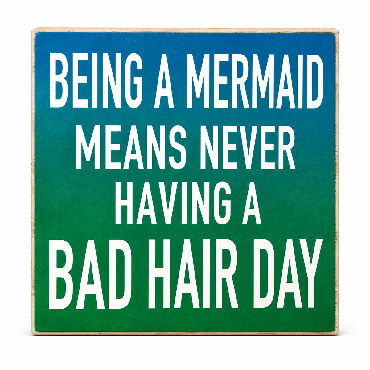 A square decorative sign with a blue-to-green gradient background and bold white text that reads, 'BEING A MERMAID MEANS NEVER HAVING A BAD HAIR DAY.'.