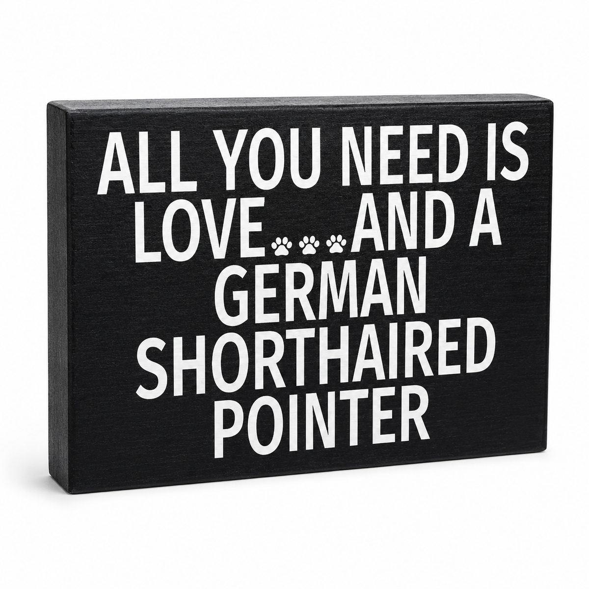 A rectangular black wooden sign with bold white text reading 'ALL YOU NEED IS LOVE.