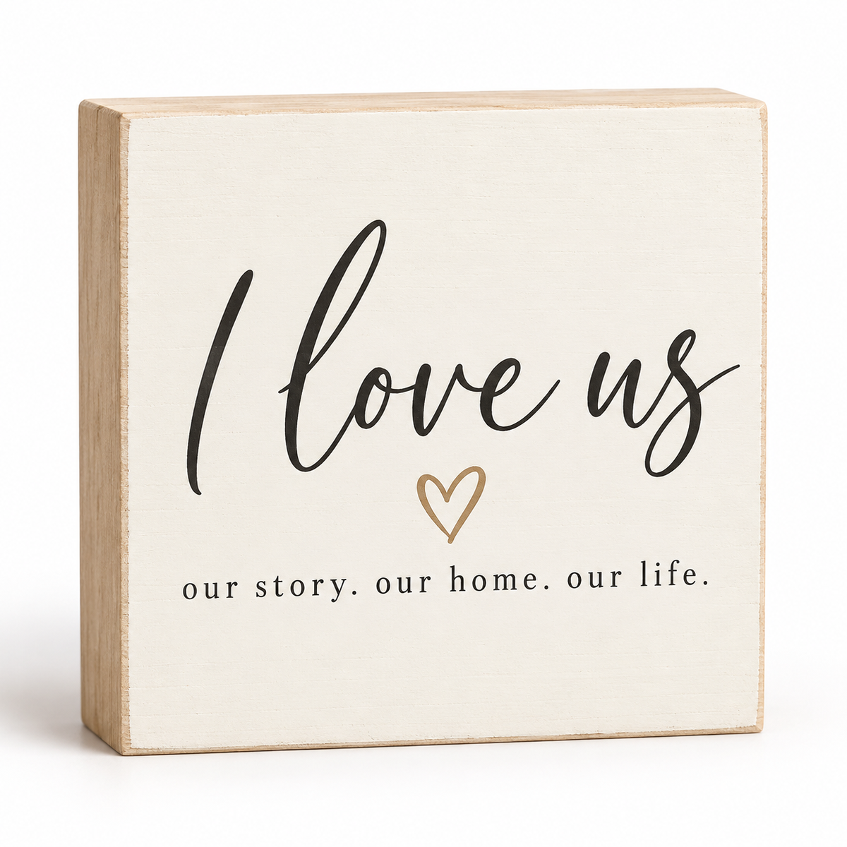 A square decorative wooden block sign with a light natural wood frame and a cream face. The face features the phrase 'I love us' in black script, a small gold heart outline, and the words 'our story.