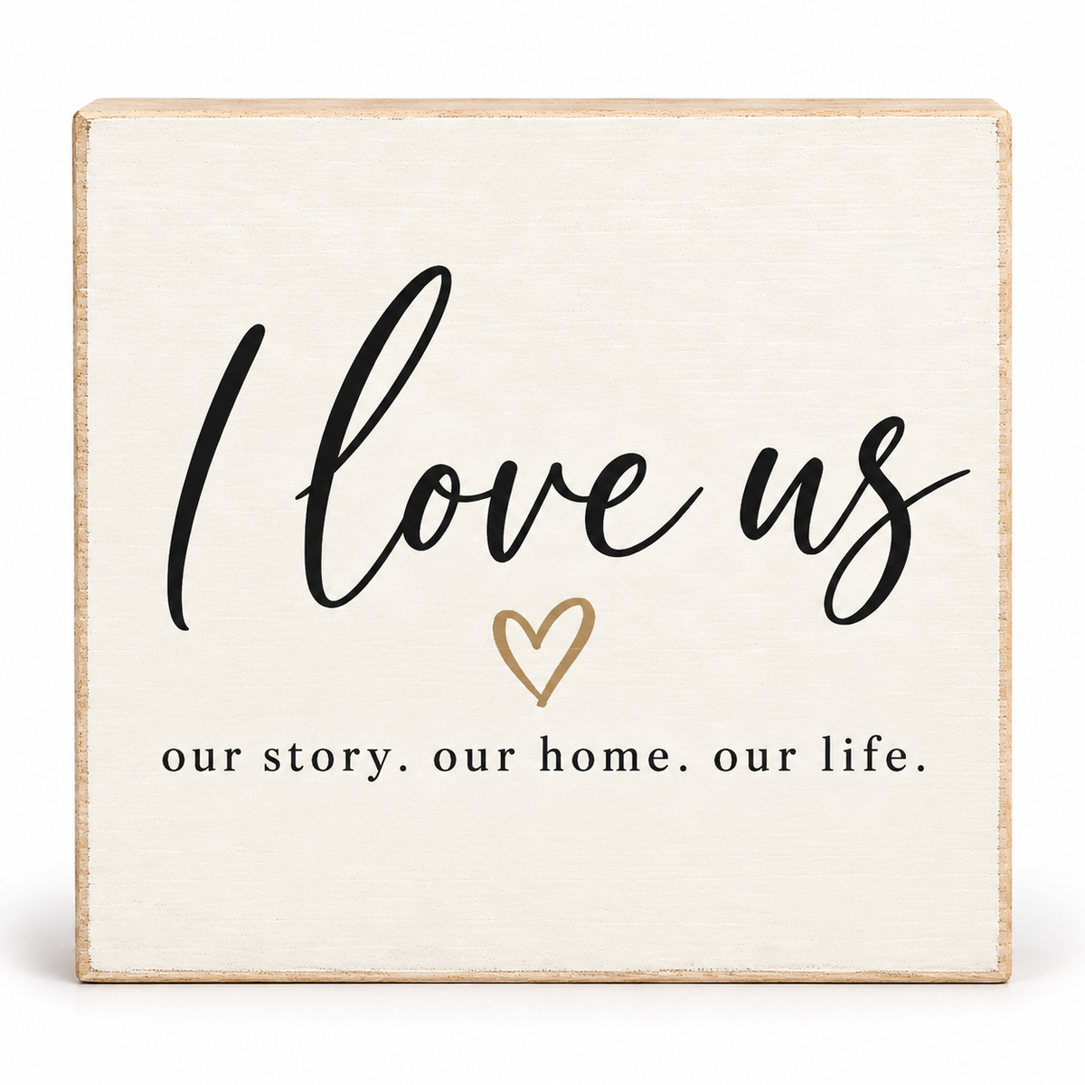 A square decorative wooden sign with a distressed cream finish and natural wood edges. The sign features the phrase 'I love us' in black script, a small gold heart outline, and the text 'our story.