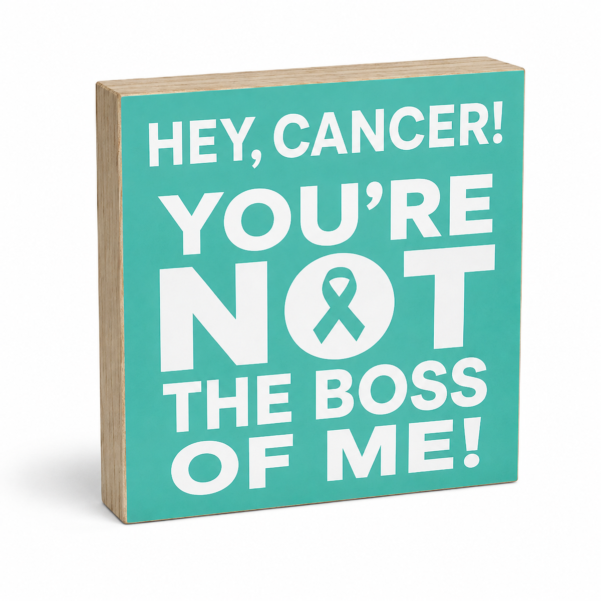A square wooden sign with a turquoise front and natural wood edges, featuring the text 'HEY, CANCER! YOU'RE NOT THE BOSS OF ME!' in bold white lettering with a teal ribbon symbol inside the letter O.