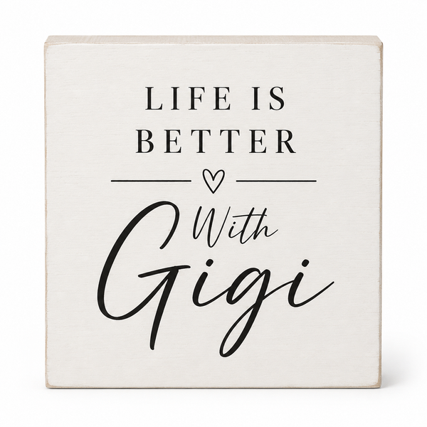 A square decorative sign with a distressed off-white wood finish and black text that reads 'LIFE IS BETTER With Gigi' and a small heart, shown on a clean white background.