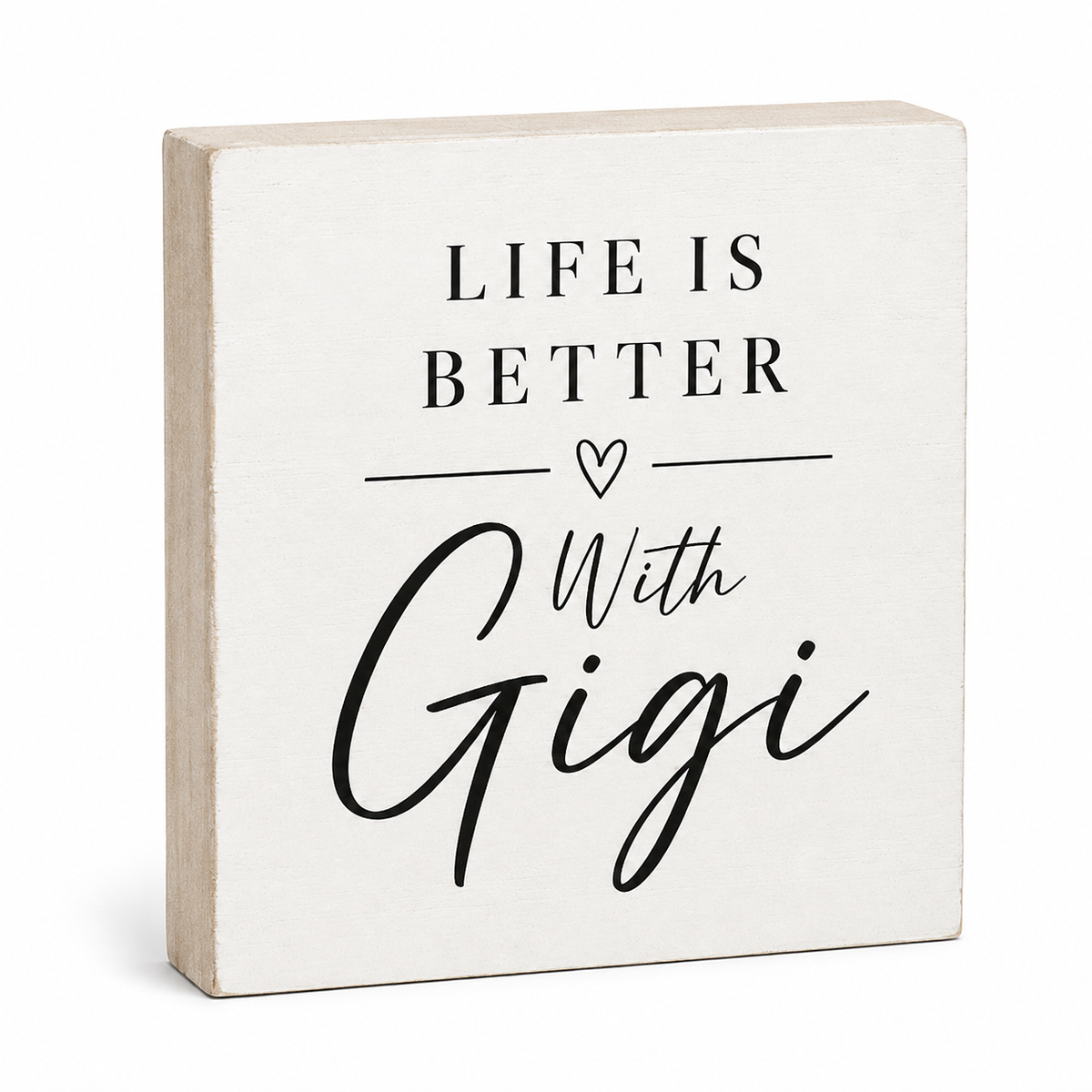 A square decorative wooden block sign with a light natural wood edge and a white front face, printed with the phrase “LIFE IS BETTER With Gigi” in black text and a small heart icon, shown on a clean white background.