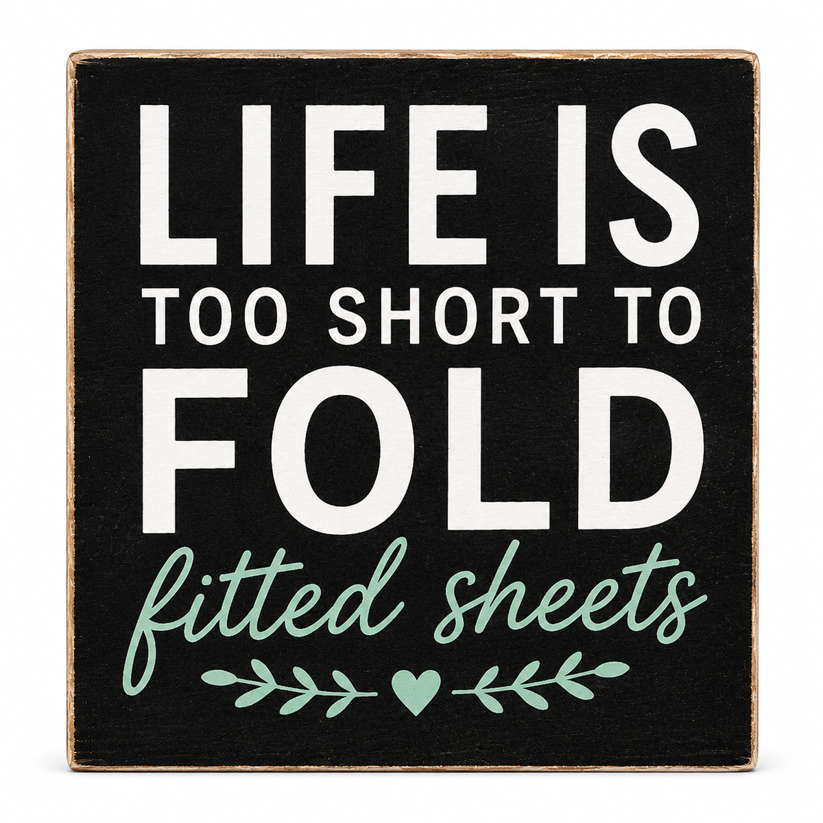 A square decorative sign with a black face and natural wood edges, featuring the phrase “LIFE IS TOO SHORT TO FOLD fitted sheets” in white and mint green lettering, on a white background.