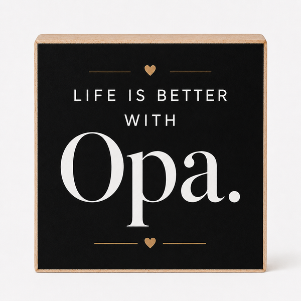 Square decorative wall sign with a black face and natural wood edges, reading “LIFE IS BETTER WITH Opa.” in white text with small gold heart and line accents, shown on a light gray background.