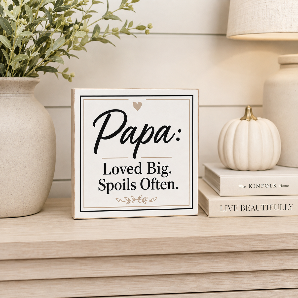 A square decorative sign with the text 'Papa: Loved Big. Spoils Often.